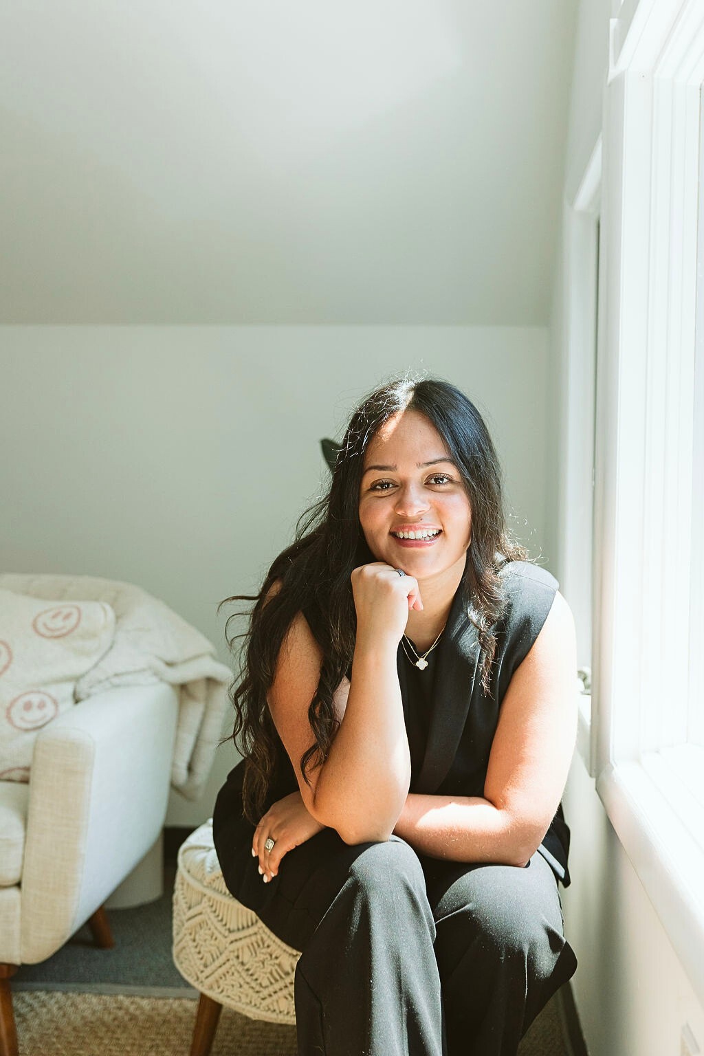 Portrait of Erika Valencia, holistic psychotherapist at Mindfully Life, smiling warmly in a bright and serene therapy space