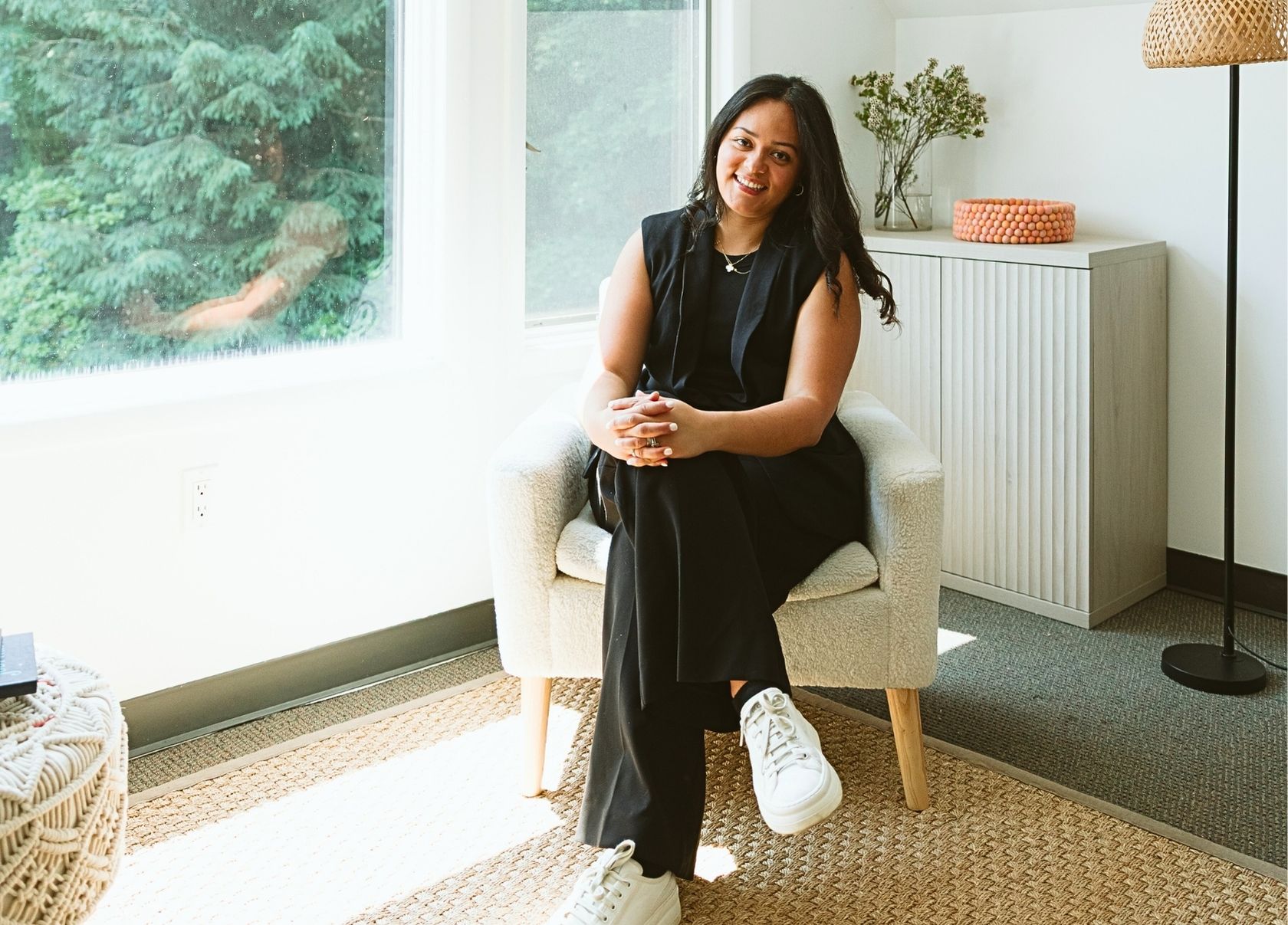 Erika Valencia, LMSW, seated and smiling in a calm, sunlit therapy office at Mindfully Life